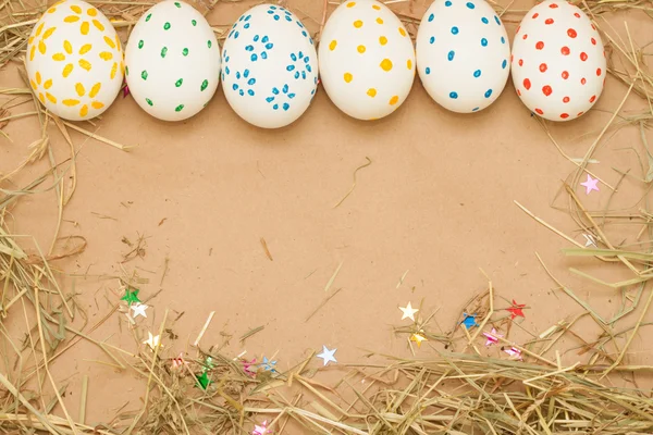 Oeufs de Pâques tachetés sur fond kraft avec du foin — Photo