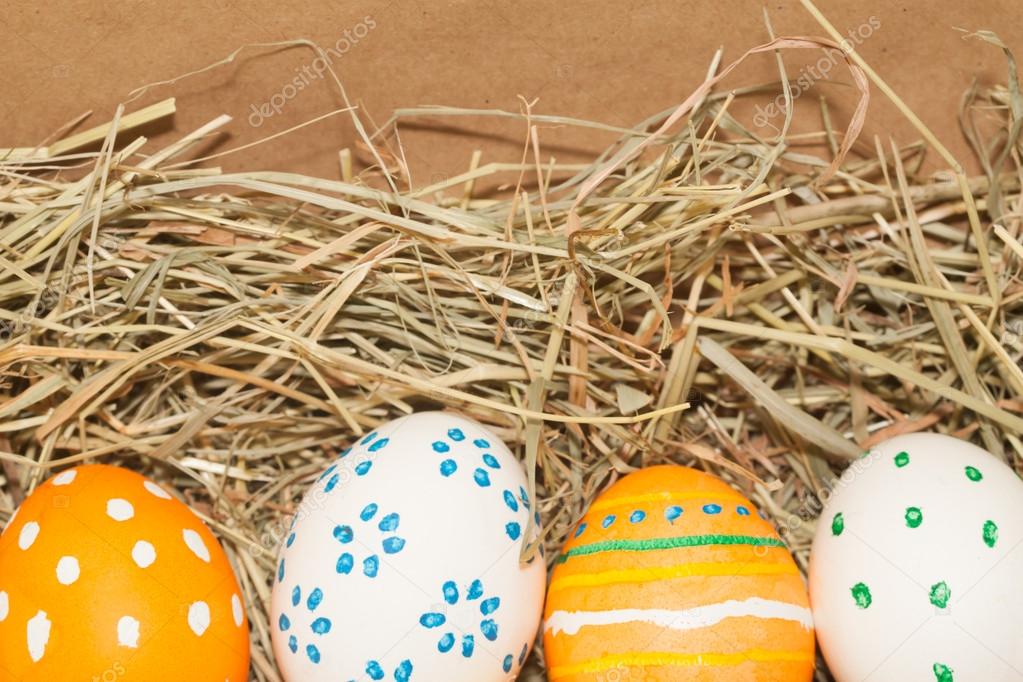 four spotted easter eggs on hay