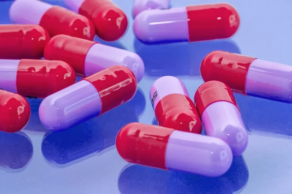 Красные и фиолетовые таблетки — стоковое фото