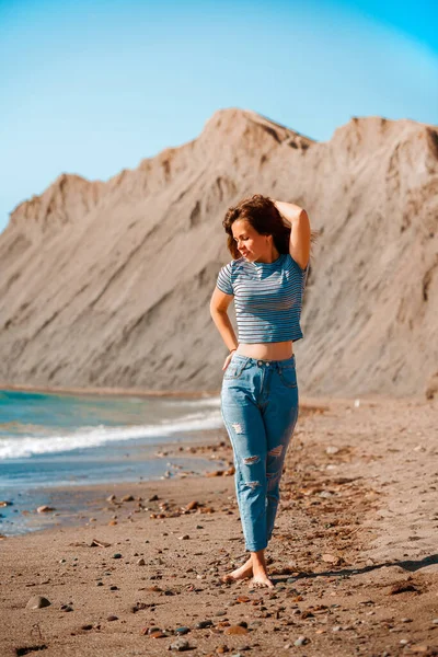 Uma Bela Jovem Morena Jeans Caminha Longo Uma Pitoresca Praia — Fotografia de Stock