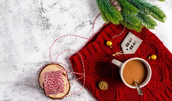 Christmas banner on a white table. The concept of a cozy home party with coffee and a warm red scarf