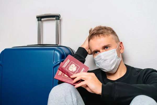 Мужчина Медицинской Маске Держит Российские Паспорта Сидит Рядом Багажом Аэропорту — стоковое фото