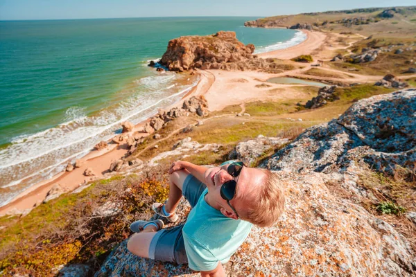 Młody Mężczyzna Siedzi Skale Plecami Kamery Podziwia Szalejące Morze Środku — Zdjęcie stockowe