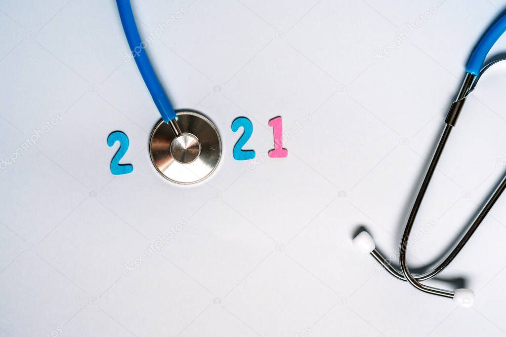 Stethoscope with the numbers 2021 on a blue background. Christmas for the health and medical banner or cover of the calendar. Creative idea.
