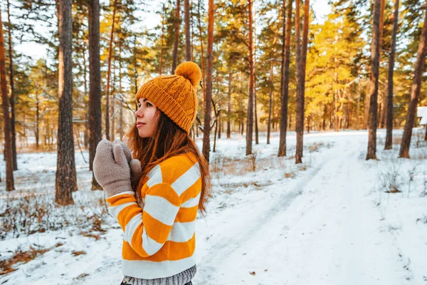 冬の松林の雪景色を背景にしたセーター姿の若い女性の肖像 — ストック写真