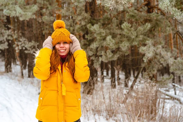 幸せな笑顔若い女性で黄色のジャケットで雪の冬の森 — ストック写真