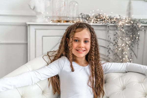 귀여운 소녀는 웃으며 크리스마스 장식이 스튜디오에서 카메라를 바라본다 — 스톡 사진