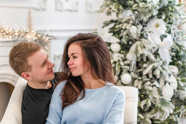在圣诞前夕 一对迷人的快乐夫妇站在装饰过的树前 彼此含情脉脉地微笑着 — 图库照片