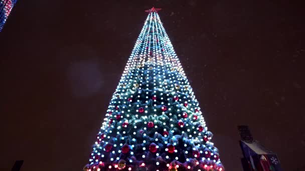 Nachts Blinkt Der Weihnachtsbaum Der Stadt Unscharfe Schneeflocken Auf Der — Stockvideo