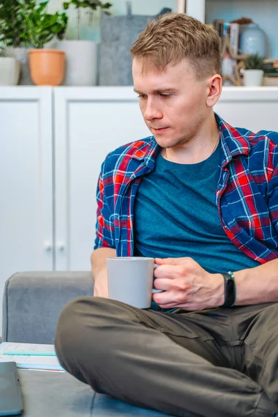 Ein Junger Mann Hält Einen Laptop Auf Seinem Schoß Während — Stockfoto