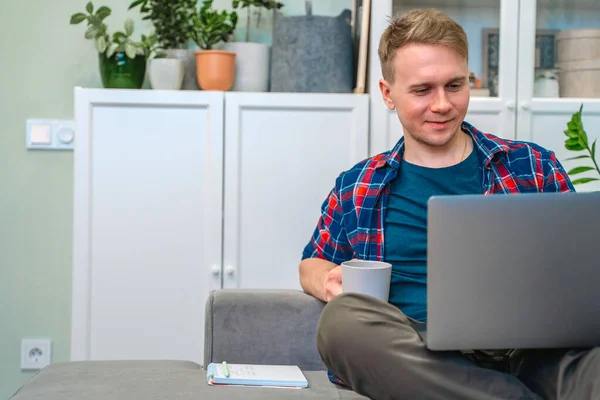 Ein Junger Mann Hält Einen Laptop Auf Seinem Schoß Während — Stockfoto