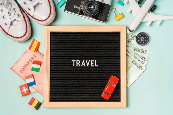 Deska Napisem Podróże Otoczona Akcesoriami Turystycznymi Podróż Pieniądze Trampki Aparat — Zdjęcie stockowe
