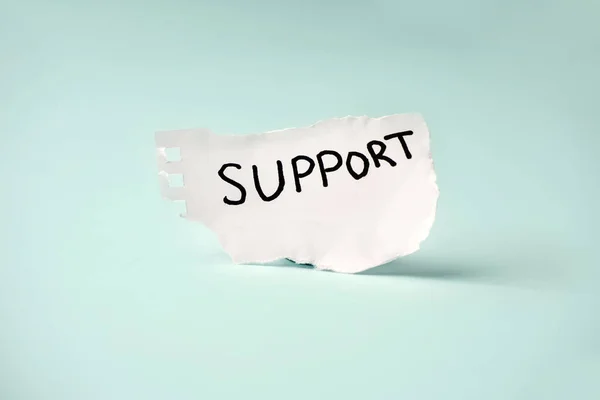 蓝色背景的白纸上的题词 Support — 图库照片