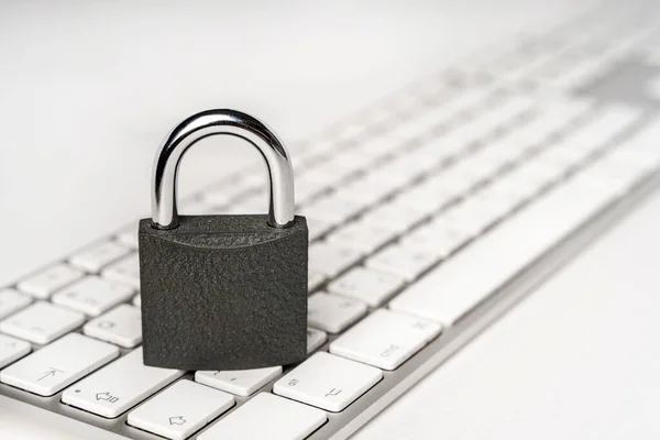 Concept of a computer security. Locked padlock on a white laptop keyboard.