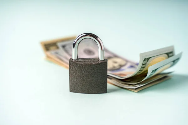 Locked lock on banknotes as a concept of financial security of deposits and money storage