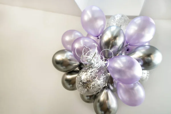 Festive purple and silver balloons fly under the ceiling, festive concept