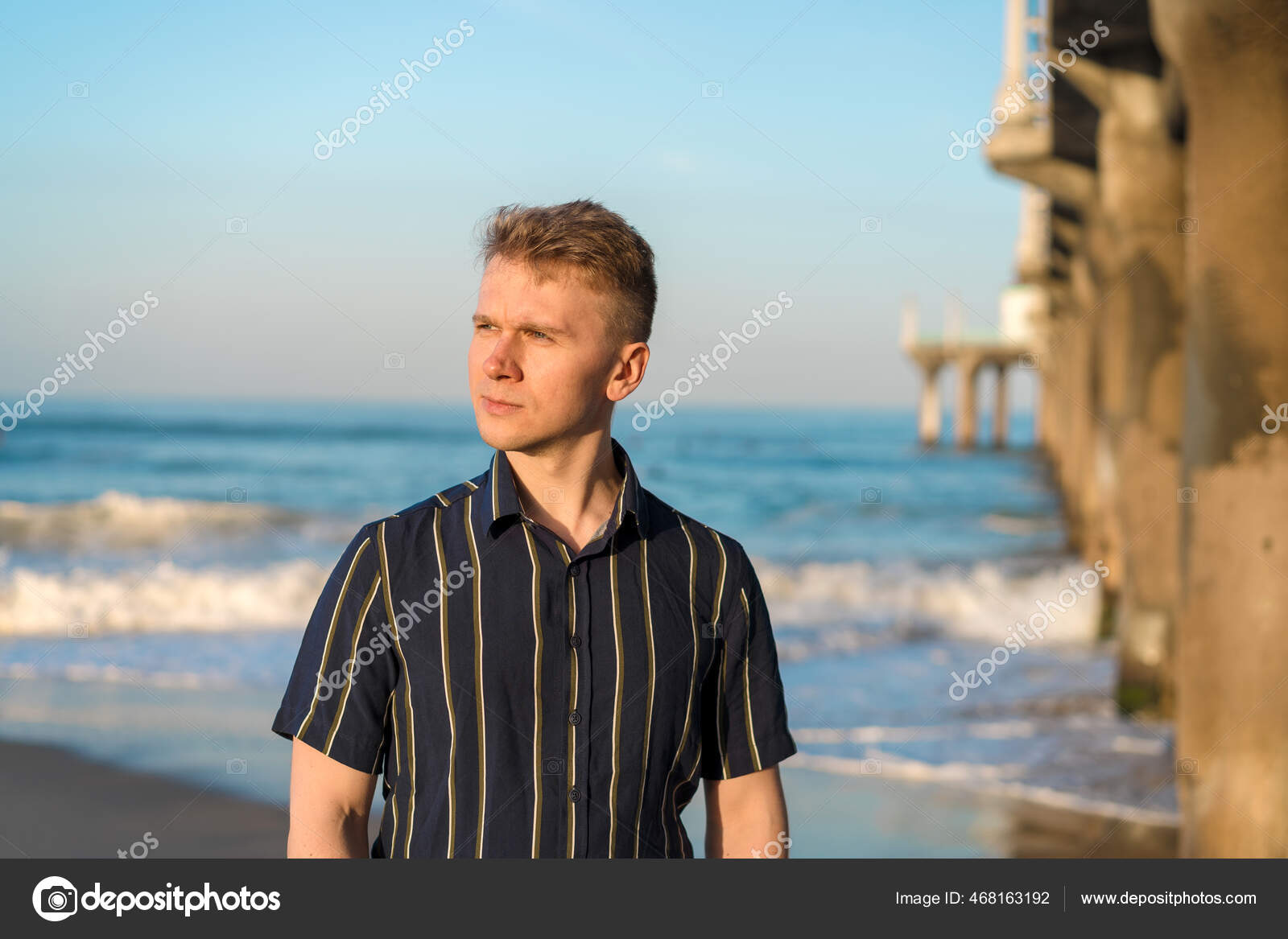 Handsome man on the beach looking into the distance Stock Photo - Alamy