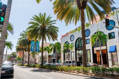 Beverly Hills sokakları, palmiye ağaçları arasından alışveriş, parlak binalar. Los Angeles, ABD - 15 Nisan 2021