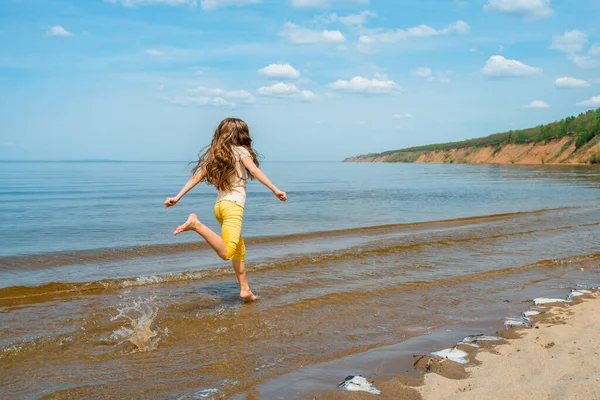 Ένα Κοριτσάκι Φωτεινό Κίτρινο Παντελόνι Τρέχει Στο Νερό Και Κατσουφιάζει — Φωτογραφία Αρχείου
