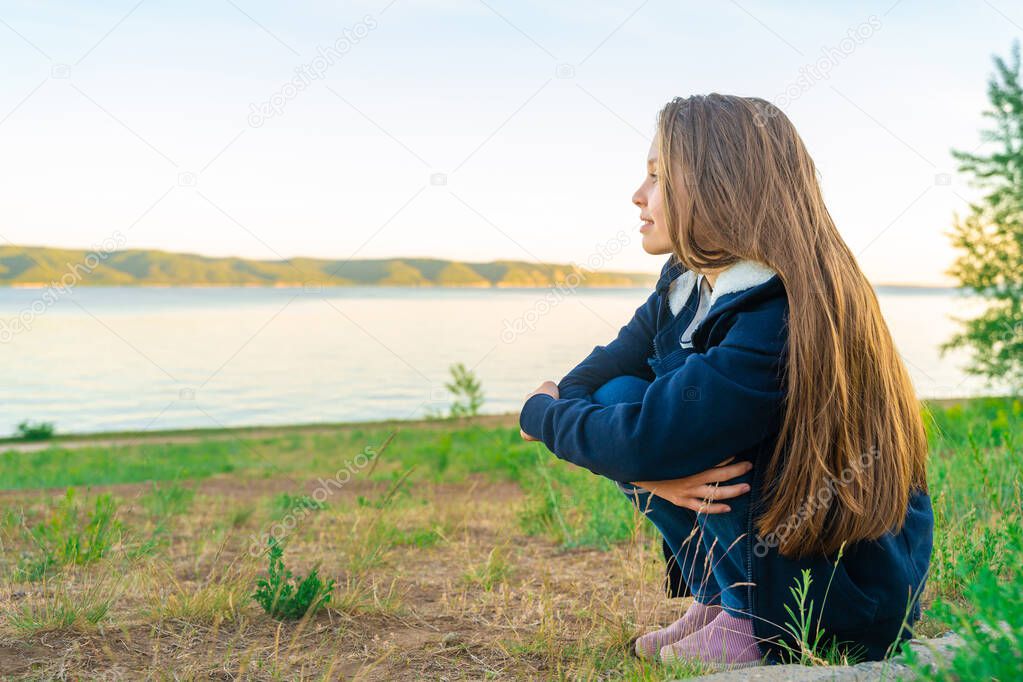 Little teen girl relaxing in the fresh air at sunset, the concept of mental health care
