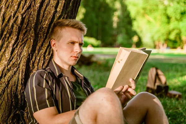 Young Man Sitting Tree Reading Book Green Summer Park Sunset — Foto Stock