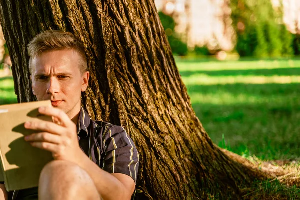 Young Man Sitting Tree Reading Book Green Summer Park Sunset — Foto Stock