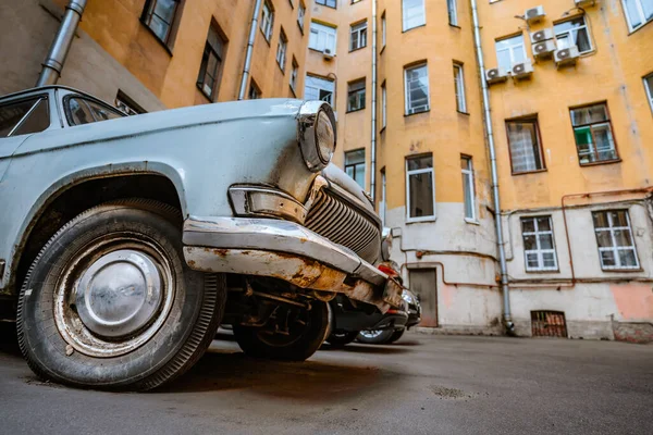 An old retro Soviet car in the courtyard of houses. Saint Petersburg, Russia - 4 July 2021