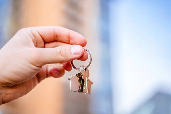 Mano Uomo Tiene Chiavi Una Nuova Casa Sullo Sfondo Grattacieli — Foto Stock