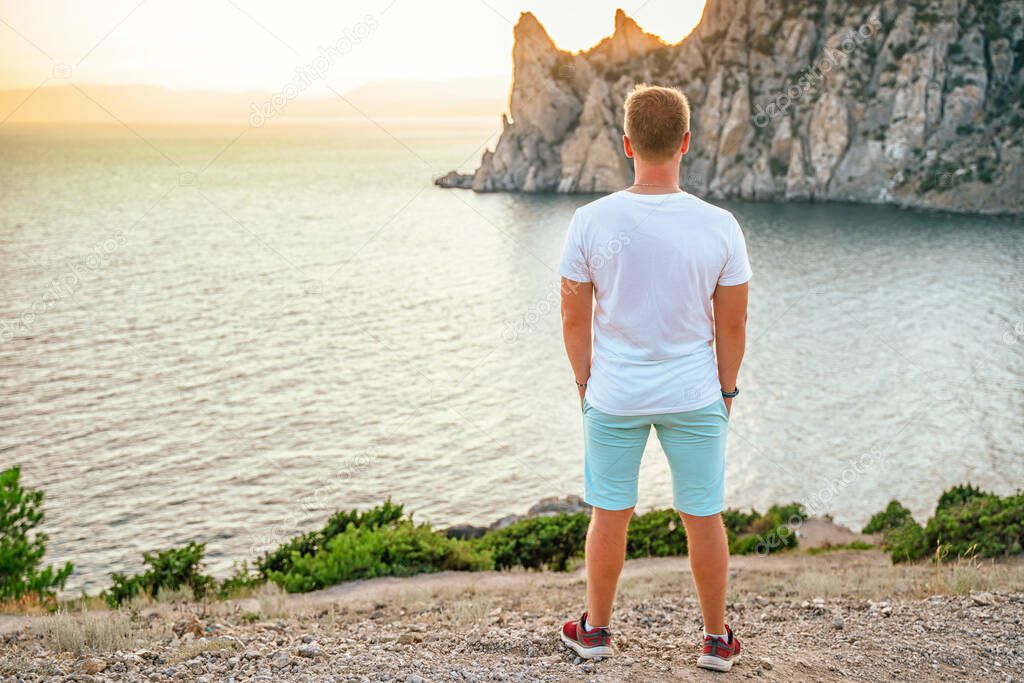 A young man tourist on Cape Kapchik in the Crimea. Seascape at sunset