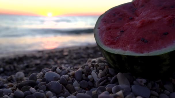 Eine Halbe Wassermelone Liegt Strand Mit Kieselsteinen Bei Sonnenuntergang Das — Stockvideo