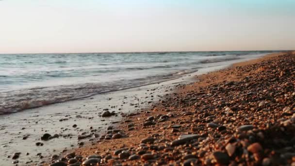 4K视频 日落时带着鹅卵石在海滩上荡漾 太阳进入水中 平静和禅意的概念 — 图库视频影像
