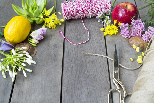 Natura morta di disporre fiori e frutta su sfondo di legno — Foto Stock