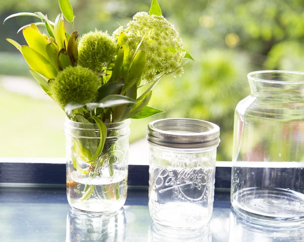 Flower in glass jar with bokeh background — Stock Photo, Image