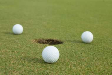3 golf topu deliğe yanında 