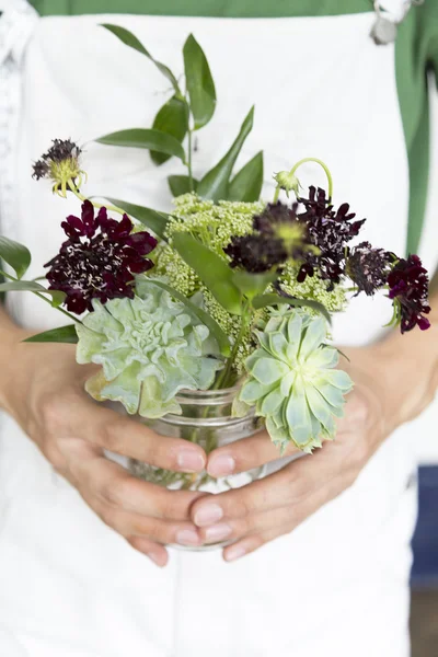 Květy a listy kytice drží v rukou lidí — Stock fotografie