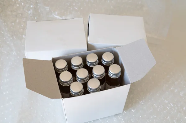 Медицинские бутылки в белой бумажной коробке и пузырьке воздуха — стоковое фото