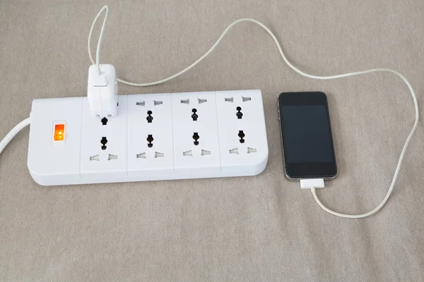 電源コードに携帯電話を充電します。 — ストック写真