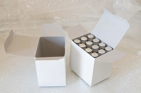 Medicin flaskor i vitboken box och luft bubbla — Stockfoto