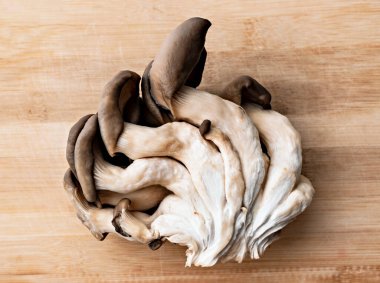 Taze kesilmiş istiridye mantarları açık tahta arka planda yakın plan, sağlıklı beslenme, vejetaryen yiyecekler.