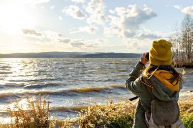 Göldeki kuşlara dürbünle bakan genç bir kadın. Kuş izleme, zooloji, ekoloji. Doğa araştırmaları, hayvanların gözlemi. Kuşbilim