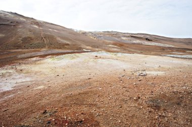 Kuzey İzlanda 'daki Hver jeotermal alanı, volkan çamuru ve çatlamış kırmızı zemin