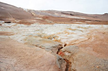 Kuzey İzlanda 'daki Hver jeotermal alanı, volkan çamur kapları ve çatlamış kırmızı zemin