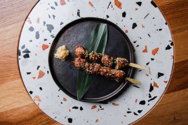 Yeşil yapraklı bir şişte ızgara kebap.