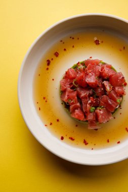 Avokado püresi soslu somon dilimli bir tabağın üst görüntüsü.