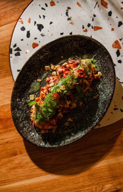 Ahşap arka planda sebzeli ve soslu ızgara somon balığı yakın plan görüntüsü.