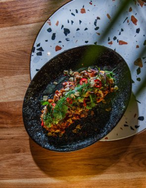 Ahşap arka planda sebzeli ve soslu ızgara somon balığı yakın plan görüntüsü.