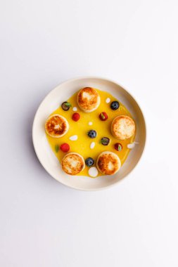 Peynirli krep, böğürtlen ve beyaz tabakta bal ile nefis bir kahvaltı manzarası. 