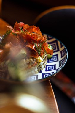 Olivier salatasının yakın plan görüntüsü tabakta jambon dilimleriyle süslenmiş.