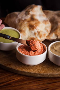 Pide dilimlerini sosa batıran bir kadın manzarası