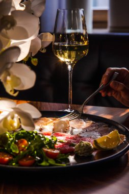 Lezzetli deniz ürünleri ve limon dilimlenmiş tabak, otlar, ahtapot dokunaçları, somon parçaları ve eski ahşap bir masada kırmızı balık filetosu.